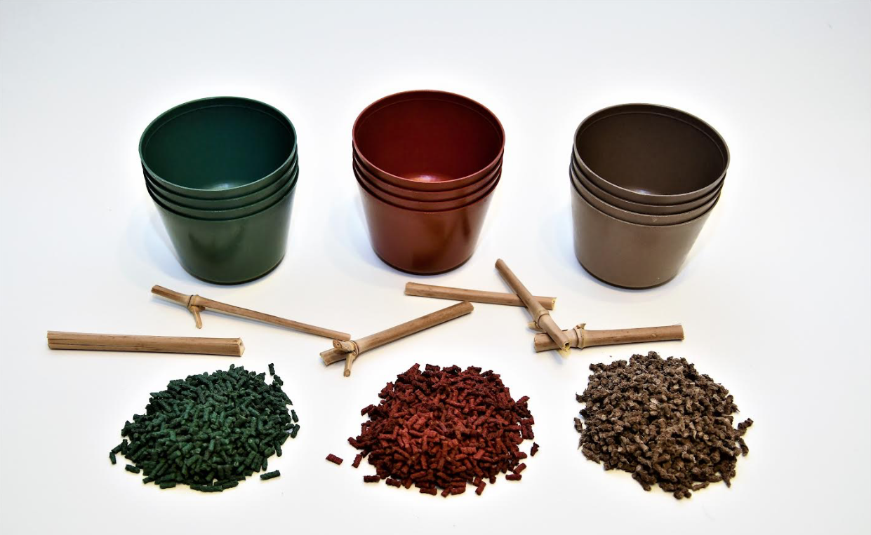 Grüne, rote und braune Töpfe von Evergreen, die aus Biokunststoff hergestellt werden. 